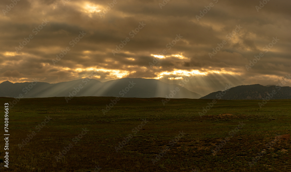 Sun Rays Breaking the Overcast Sky ina Mountain Valley
