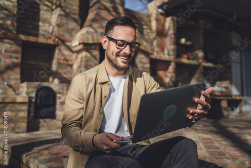 man caucasian work on laptop computer on terrace happy smile success