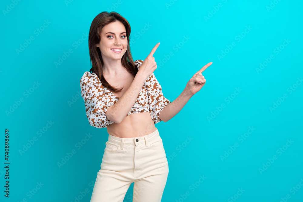 Photo of young adorable woman wearing blouse top pointing fingers empty indicating material object isolated on cyan color background Photo of young adorable woman wearing blouse top pointing fingers empty indicating material object isolated on cyan color background