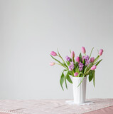 spring flowers in white vase in vintage style