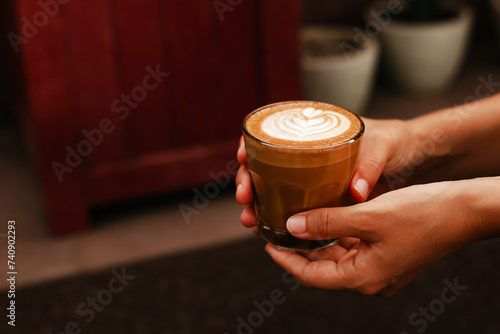 Photo Female hands holding glass with delicious latte