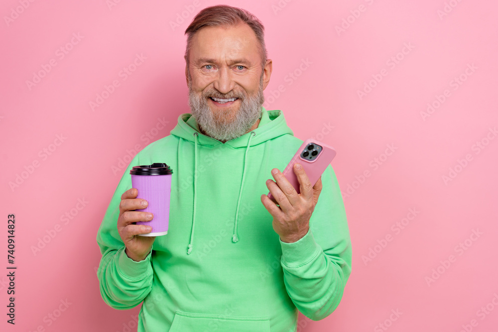 Photo of positive good mood guy dressed green hoodie enjoying coffee chatting instagram twitter telegram facebook isolated pink color background Photo of positive good mood guy dressed green hoodie enjoying coffee chatting instagram twitter telegram facebook isolated pink color background