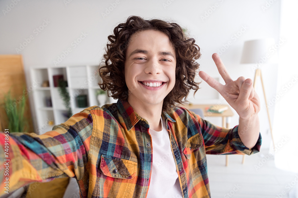 Photo of cool cheerful guy dressed checkered shirt tacking selfie showing v-sign indoors house home room Photo of cool cheerful guy dressed checkered shirt tacking selfie showing v-sign indoors house home room
