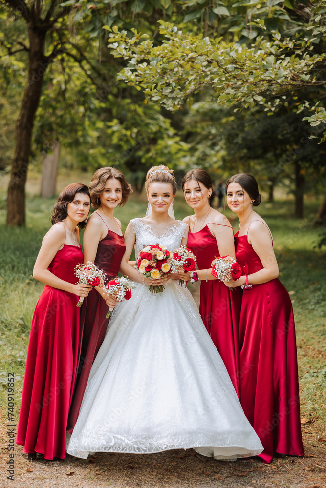 Wedding photography. A brunette bride in a white dress with a bouquet and her brunette girlfriends