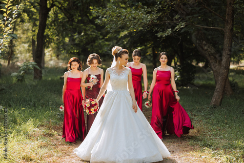 Wedding photography. A brunette bride in a white dress with a bouquet and her brunette girlfriends © Vasil