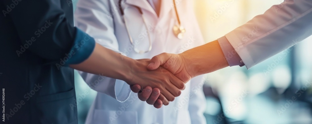 Doctor or medician shaking hands with patient.