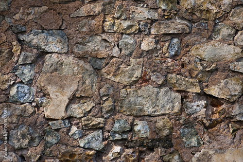 in the photo there is a close-up of an old stone wall