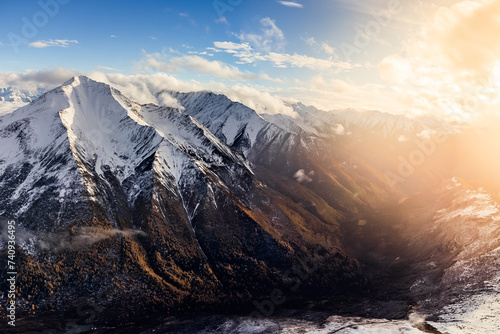 Bird's eye view from drone of snow mountain ridge and peak with cloud at sunset time at Dafeng base camp on the Siguniang Shan mountain in Changping Gou National Parks ,Rilong,Chengdu, China