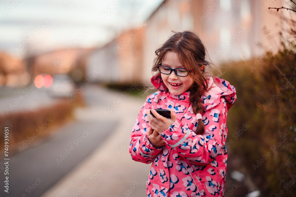 Delighted Young Girl Using Smartphone Outdoors with Excitement