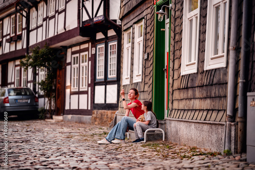 Mother and child sharing a quiet moment on a historic city street © Иванна Емельянова