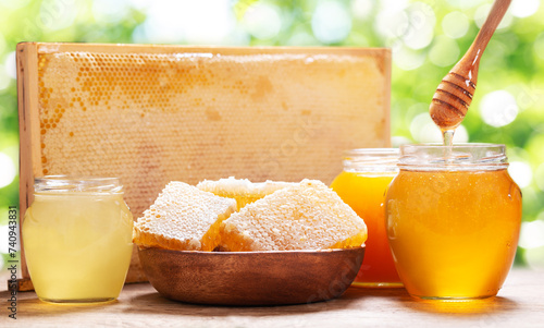 Various types of honey in glass jars and honeycomb