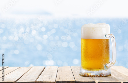 mug of beer on wooden table on sea background