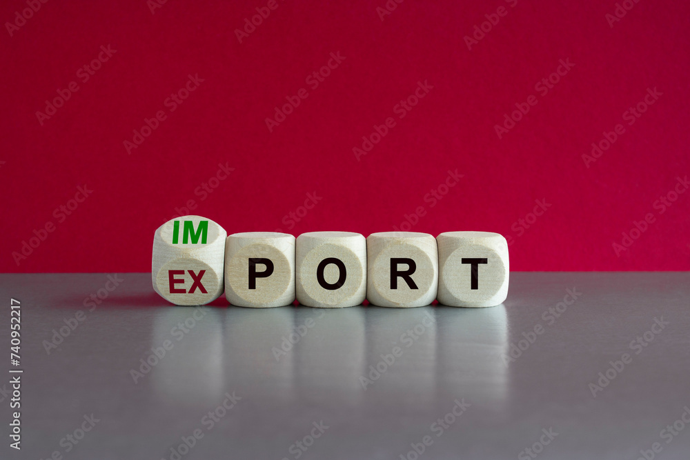 Export or import symbol. Export and import printed on cubes . Beautiful gray table, pink background, copy space. Business and big or small fees concept. Export or import symbol. Export and import printed on cubes . Beautiful gray table, pink background, copy space. Business and big or small fees concept.