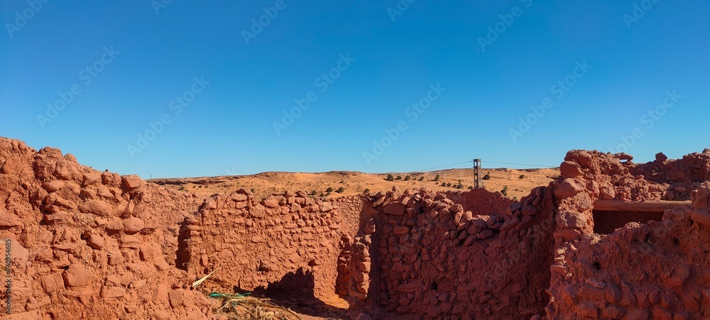 the remains of Ksar d'Ighzer, ruins of ancient stone and red clay houses, a village in the middle of the desert in the town of Timimoun, Algeria the remains of Ksar d'Ighzer, ruins of ancient stone and red clay houses, a village in the middle of the desert in the town of Timimoun, Algeria