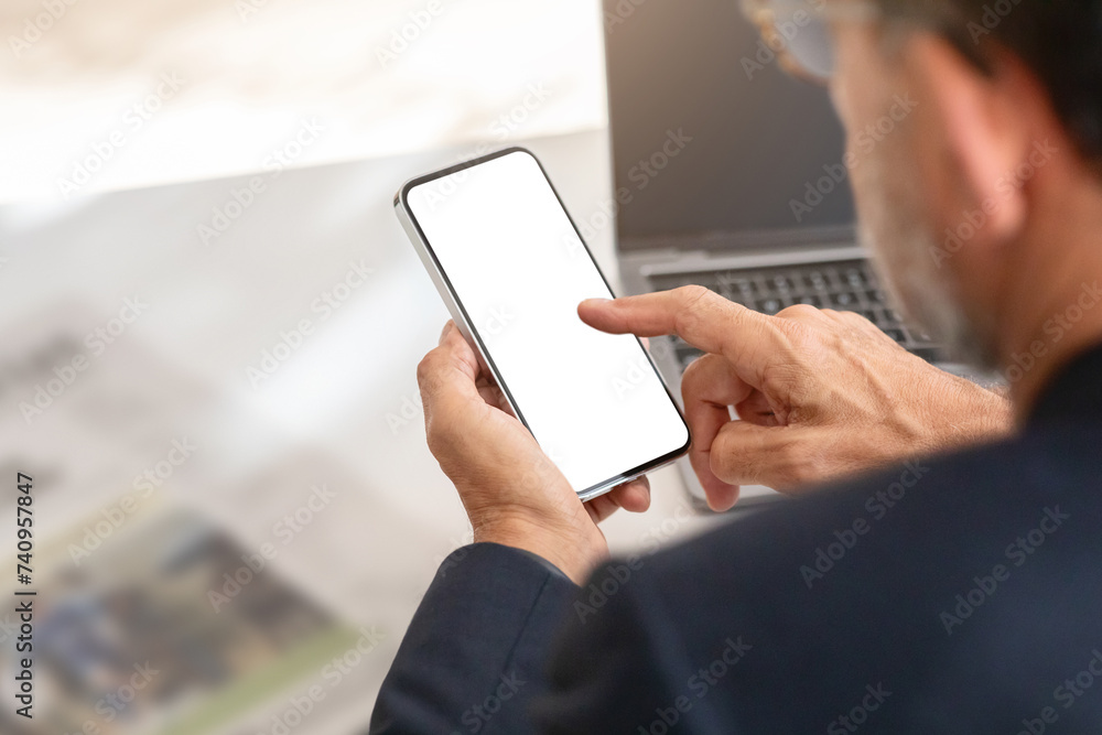 Close-up of a senior man in a suit interacting with a smartphone with a blank screen