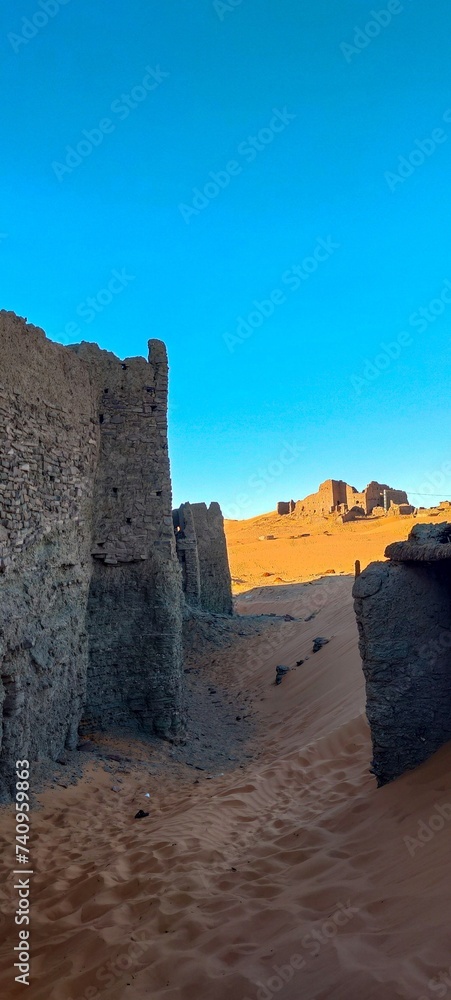 View of the remains of Ksour d'Aghlad, ruins of ancient castles made of stone and red clay in the middle of the desert in the town of Timimoun, Algeria