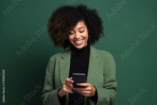 Happy African American woman with phone on Forest Green studio background