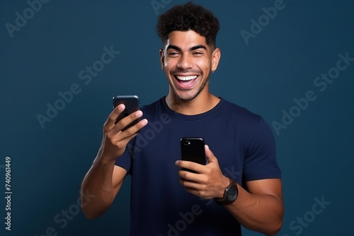 Happy Latin American man with phone on Navy studio background © AI_images
