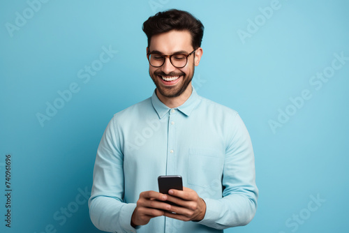 Man with phone on blue studio background © AI_images