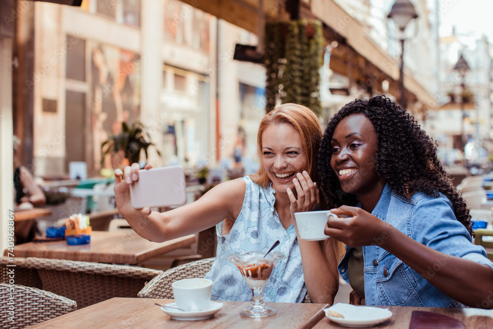 Two young women taking selfie in street cafe Two young women taking selfie in street cafe