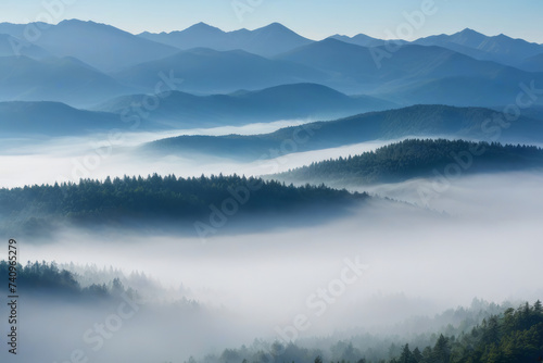 Mist-engulfed peaks rise above a dense forest. Morning fog © Anna