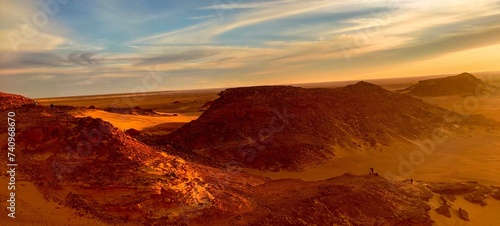 Panoramic sunset view from Timimoun, Algeria, overlooking the red sand desert and canyons from a hilltop. photo