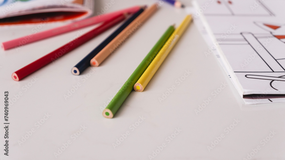 Mock up. Sketchbook. Template. On the table lies a white sheet with colored pencils Mock up. Sketchbook. Template. On the table lies a white sheet with colored pencils