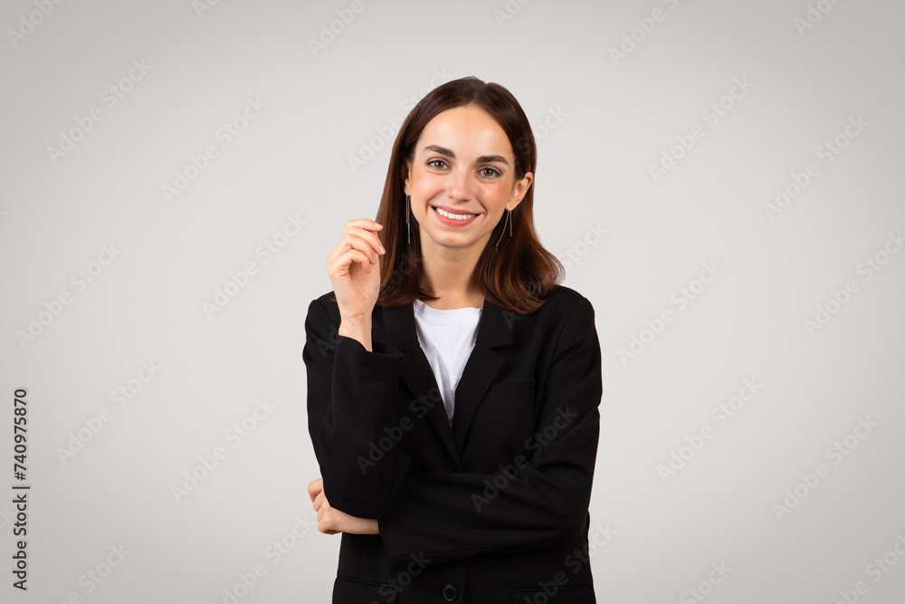Smiling businesswoman with a confident look, pointing her finger up as if having a bright idea or presenting a solution Smiling businesswoman with a confident look, pointing her finger up as if having a bright idea or presenting a solution