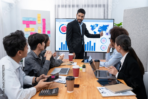 Businessman presenting data analysis dashboard display on TV screen in modern meeting for marketing strategy. Business presentation with group of business people in conference room. Concord