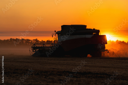 Combine harvester on the field at sunset