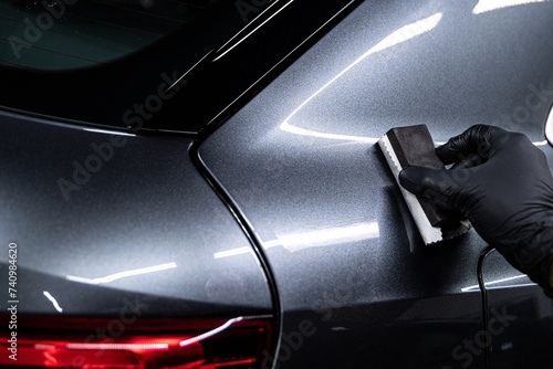 Obraz na płótnie Car detailing or car wash worker aplying ceramic coating on silver car body w salonie