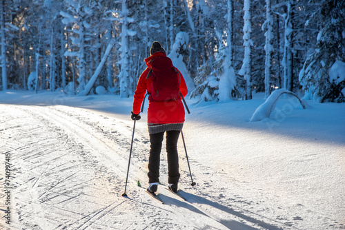 Woman cross country skiing in snowy forest