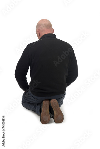 Obraz na plátně back view of a man kneeling on the floor in white background