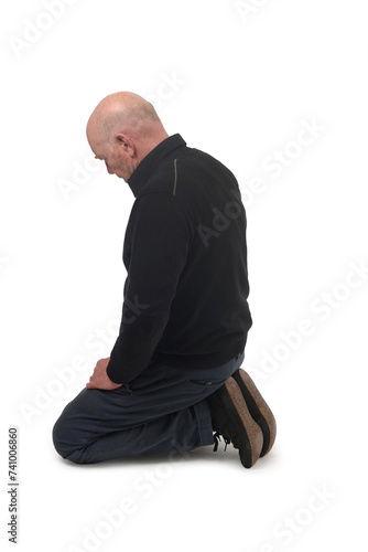 Fotografie side view of a man kneeling on the floor in white background