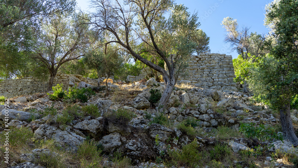 Stone wall in ancient city Amos near town or village of Turunc, Turkey. It was located in Rhodian Peraia in Caria on Mediterranean coast