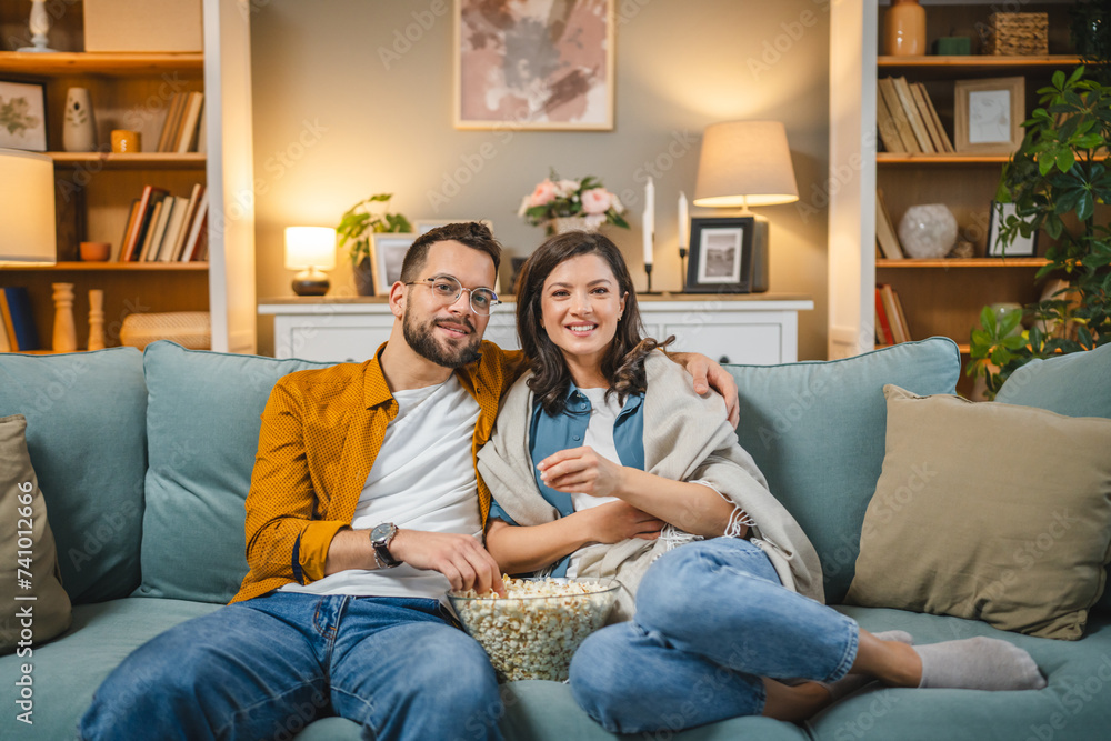 Couple caucasian man and woman sit at home on sofa bed watch tv movie