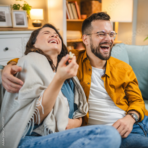 Couple caucasian man and woman sit at home on sofa bed watch tv movie photo