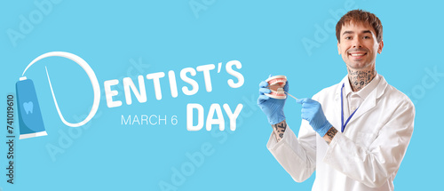Male dentist with jaw model...