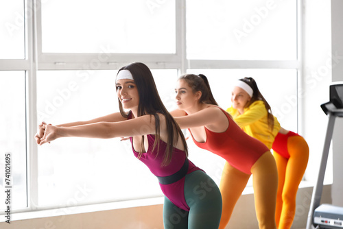 Fototapeta Naklejka Na Ścianę i Meble -  Sporty young women doing aerobics in gym
