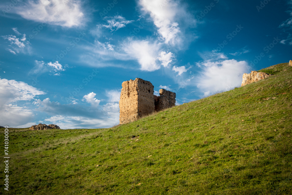 Remains of one of the doors of the medieval castle of Alcaraz, Albacete, Castilla la Mancha, Spain, on a green hill and blue sky