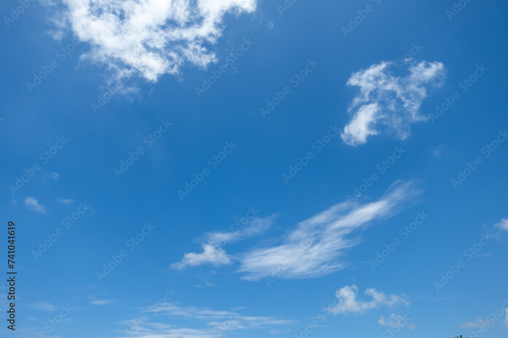 Blue sky with a few random white clouds, partly cloudiness Blue sky with a few random white clouds, partly cloudiness