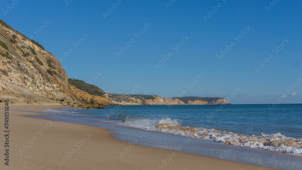 Praia da Andorinha beach on a sunny day with clear blue sky, Algarve, Portugal.