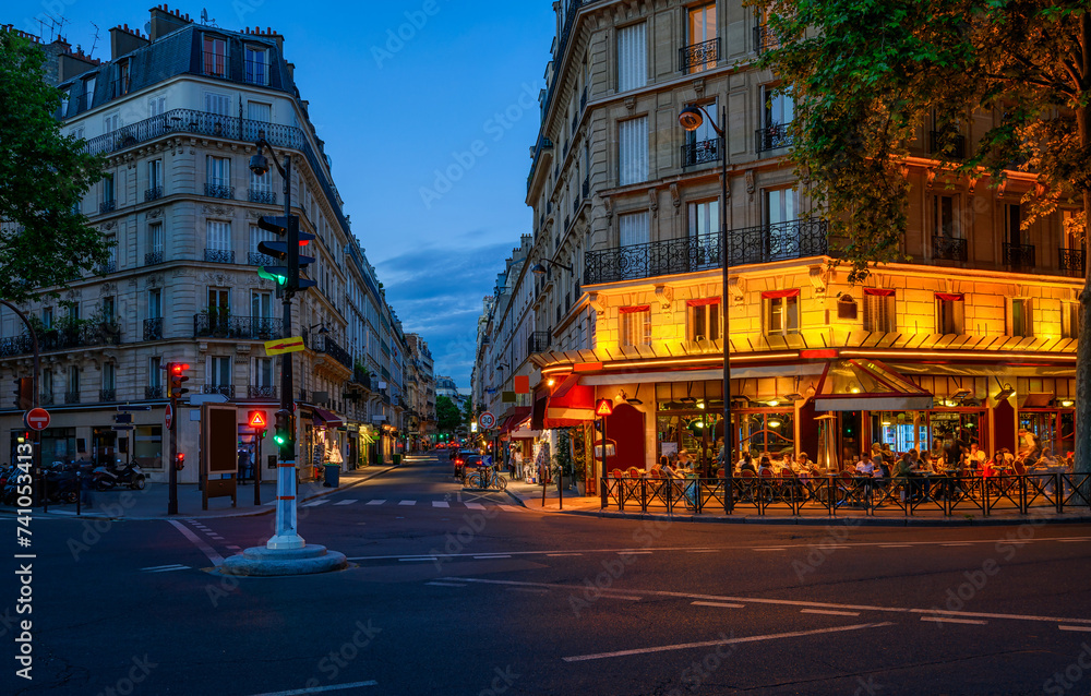Cozy street with tables of cafe in Paris, France. Night cityscape of Paris. Architecture and landmarks of Paris. - obrazy, fototapety, plakaty 