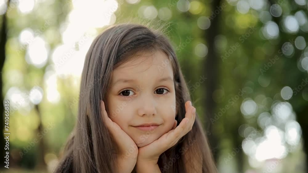Portrait of small child girl looking at camera on summer day. Young child 6-7 years thinking or dreaming with childlike curiosity close up outdoors. Face eyes serious contemplative child Portrait of small child girl looking at camera on summer day. Young child 6-7 years thinking or dreaming with childlike curiosity close up outdoors. Face eyes serious contemplative child