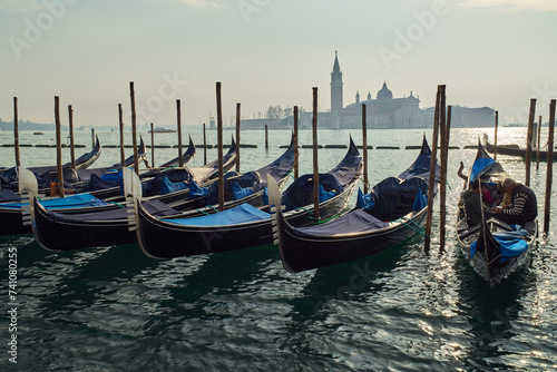 Gondolas docked at San Marco Canal with San Giorgio Maggiore island in the background in Venice, Italy	
 photo