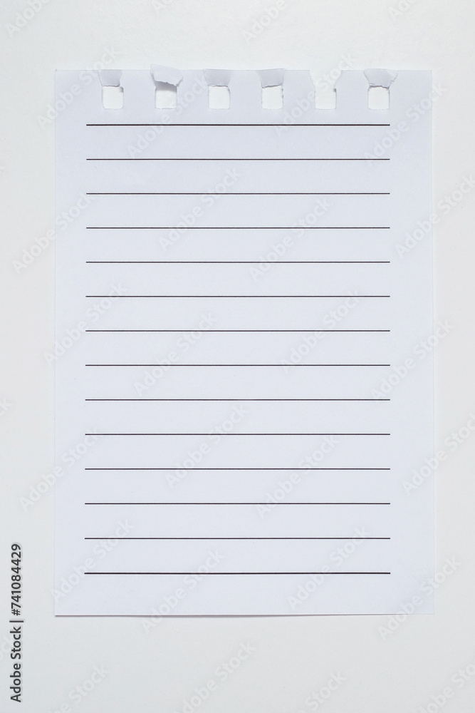 Torn page on a white vertical background. Notebook paper with black horizontal lines close-up. Lined paper with space for text, note, list. One torn empty page from a notebook Torn page on a white vertical background. Notebook paper with black horizontal lines close-up. Lined paper with space for text, note, list. One torn empty page from a notebook