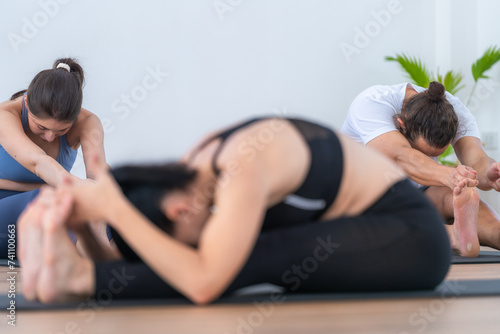 teacher woman confident training yoga. Athletic women in sportswear doing fitness stretching exercises at home in the living room. Sport and recreation concept. Yoga teacher is helping young woman.