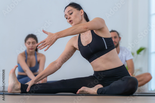 teacher woman confident training yoga. Athletic women in sportswear doing fitness stretching exercises at home in the living room. Sport and recreation concept. Yoga teacher is helping young woman.