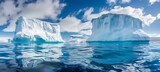 Massive white iceberg in clear blue sea, under and above water view in the arctic environment.