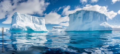 Massive white iceberg in clear blue sea, under and above water view in the arctic environment.